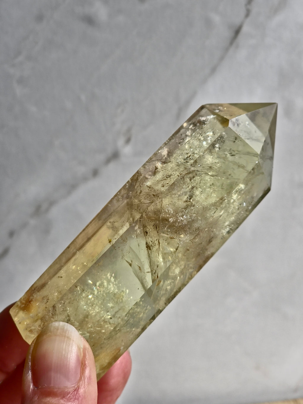 Natural citrine polished point featuring phantom formations and rainbow inclusion