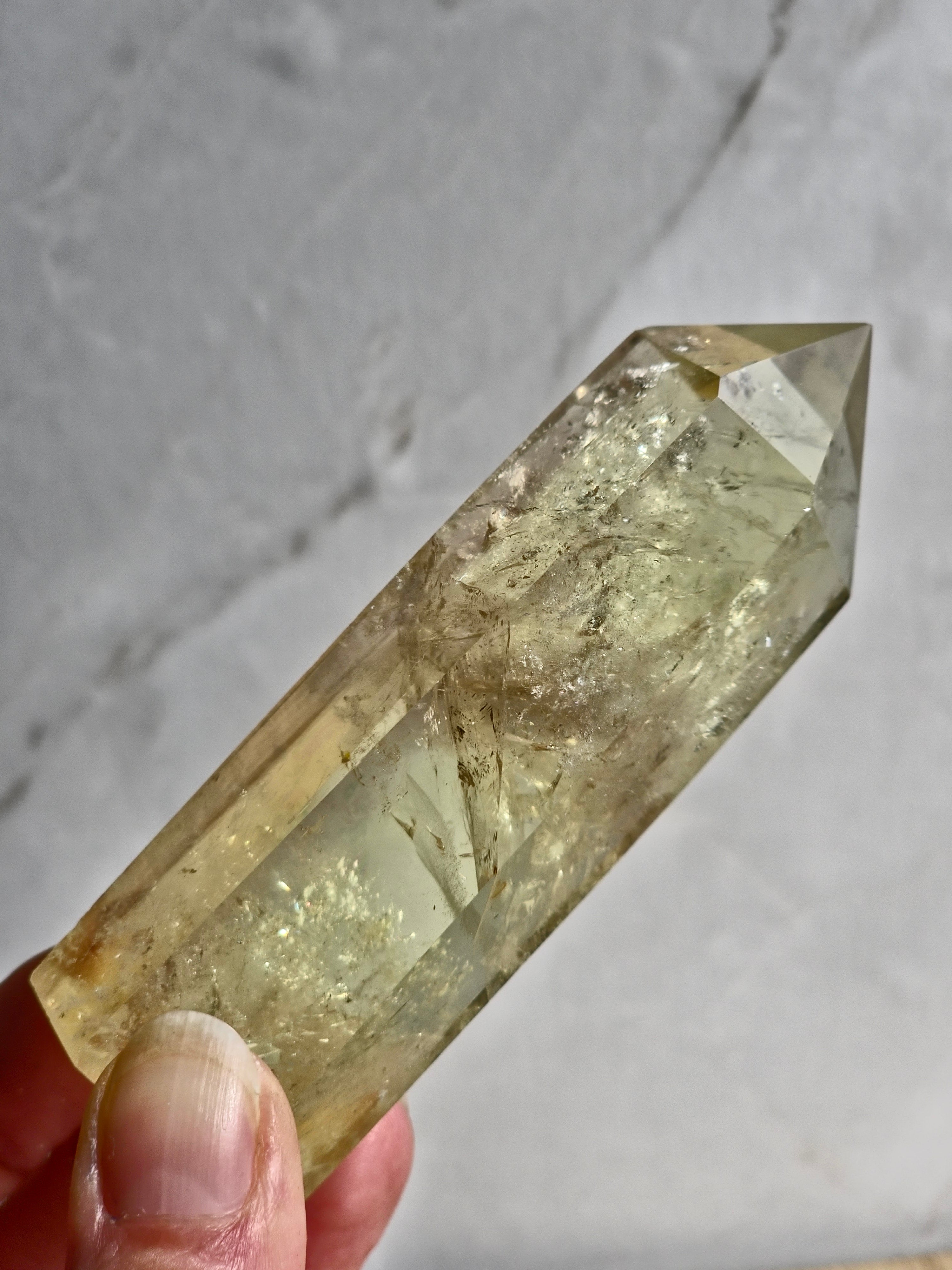 Natural citrine polished point featuring phantom formations and rainbow inclusion
