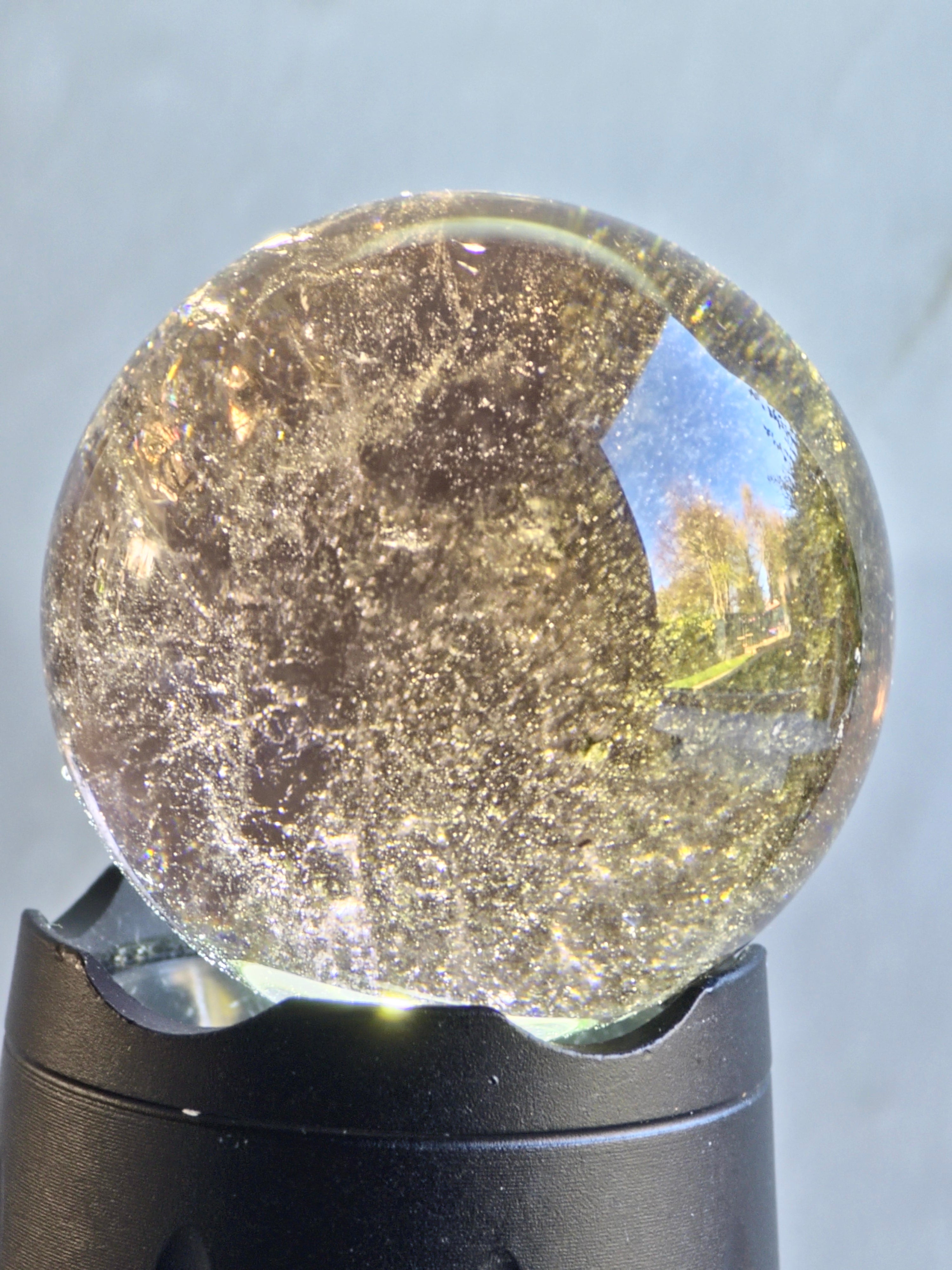 Smoky quartz sphere with green chlorite inclusions and rainbow