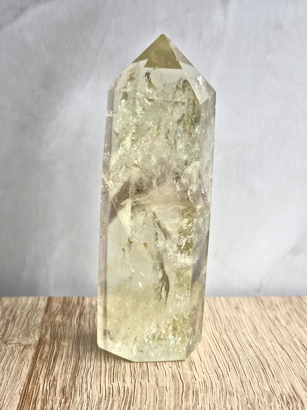 Natural citrine polished point featuring phantom formations and rainbow inclusion