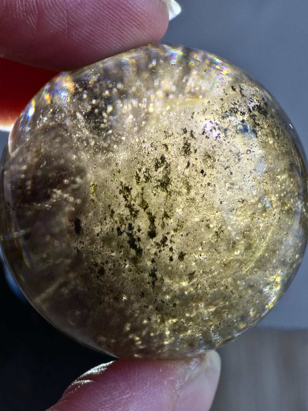 Smoky quartz sphere with green chlorite inclusions and rainbow