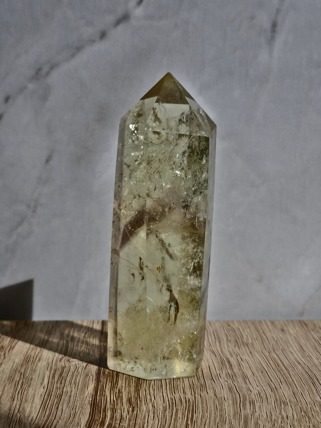Natural citrine polished point featuring phantom formations and rainbow inclusion