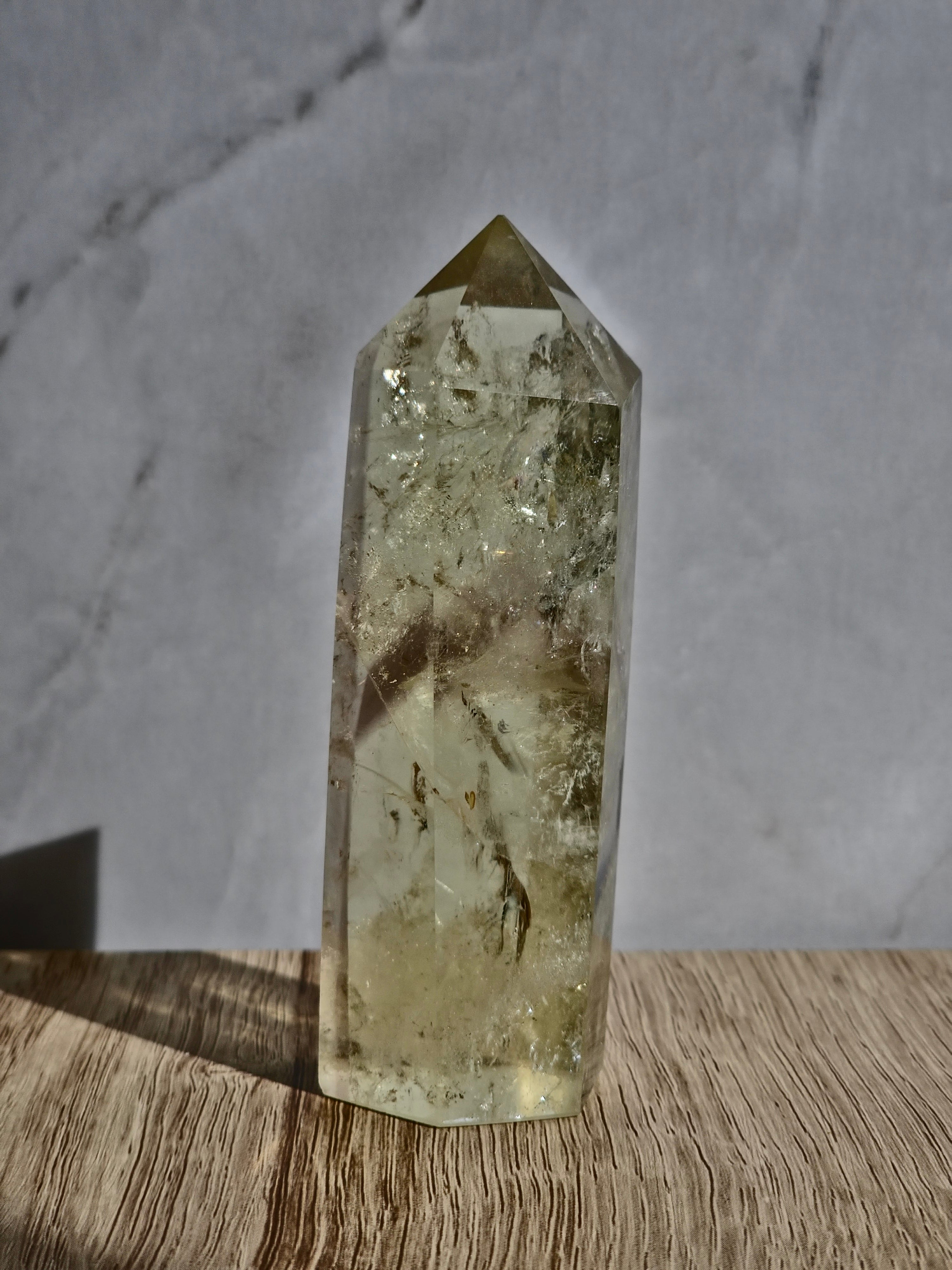 Natural citrine polished point featuring phantom formations and rainbow inclusion