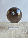Smoky quartz sphere with green chlorite inclusions and rainbow