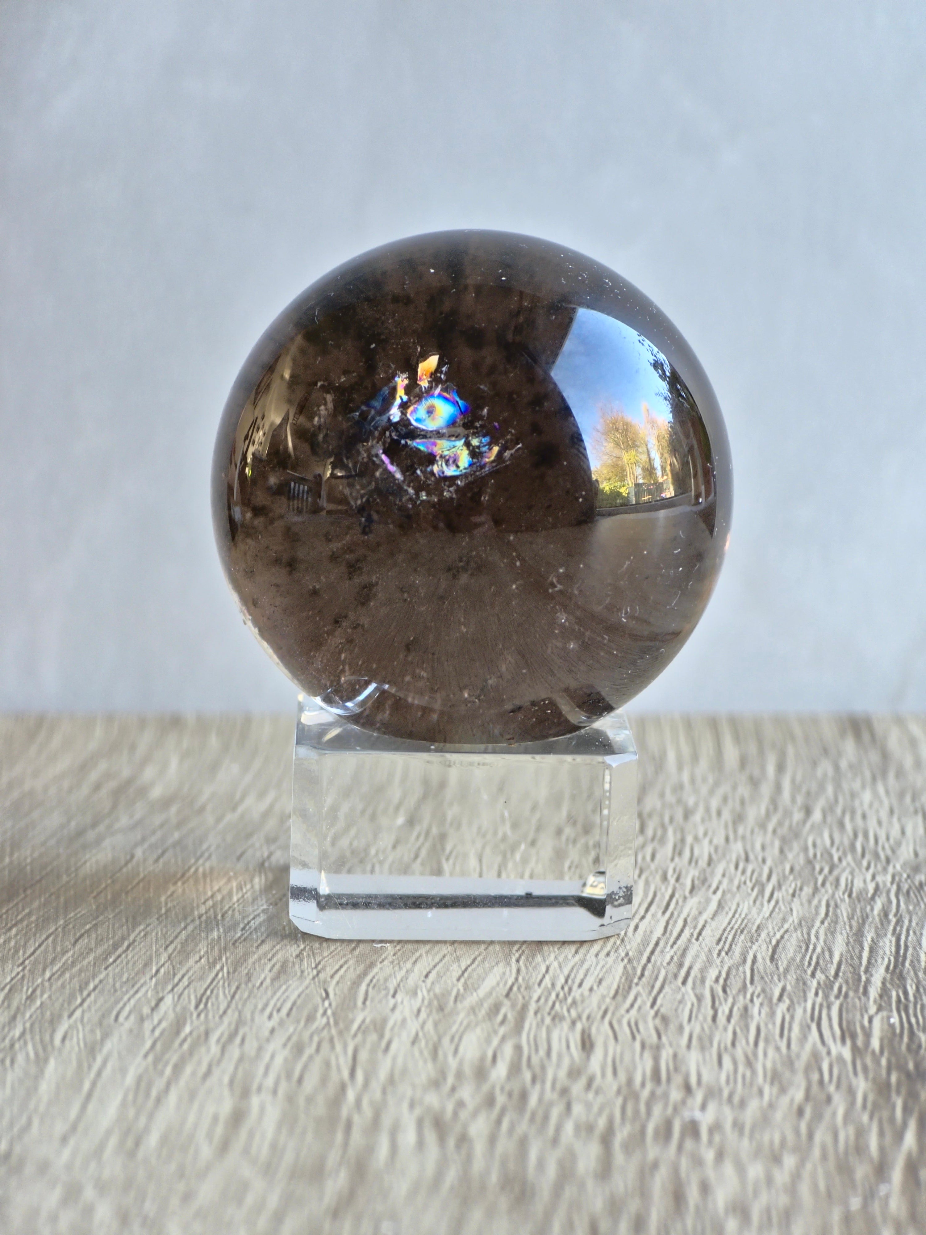 Smoky quartz sphere with green chlorite inclusions and rainbow