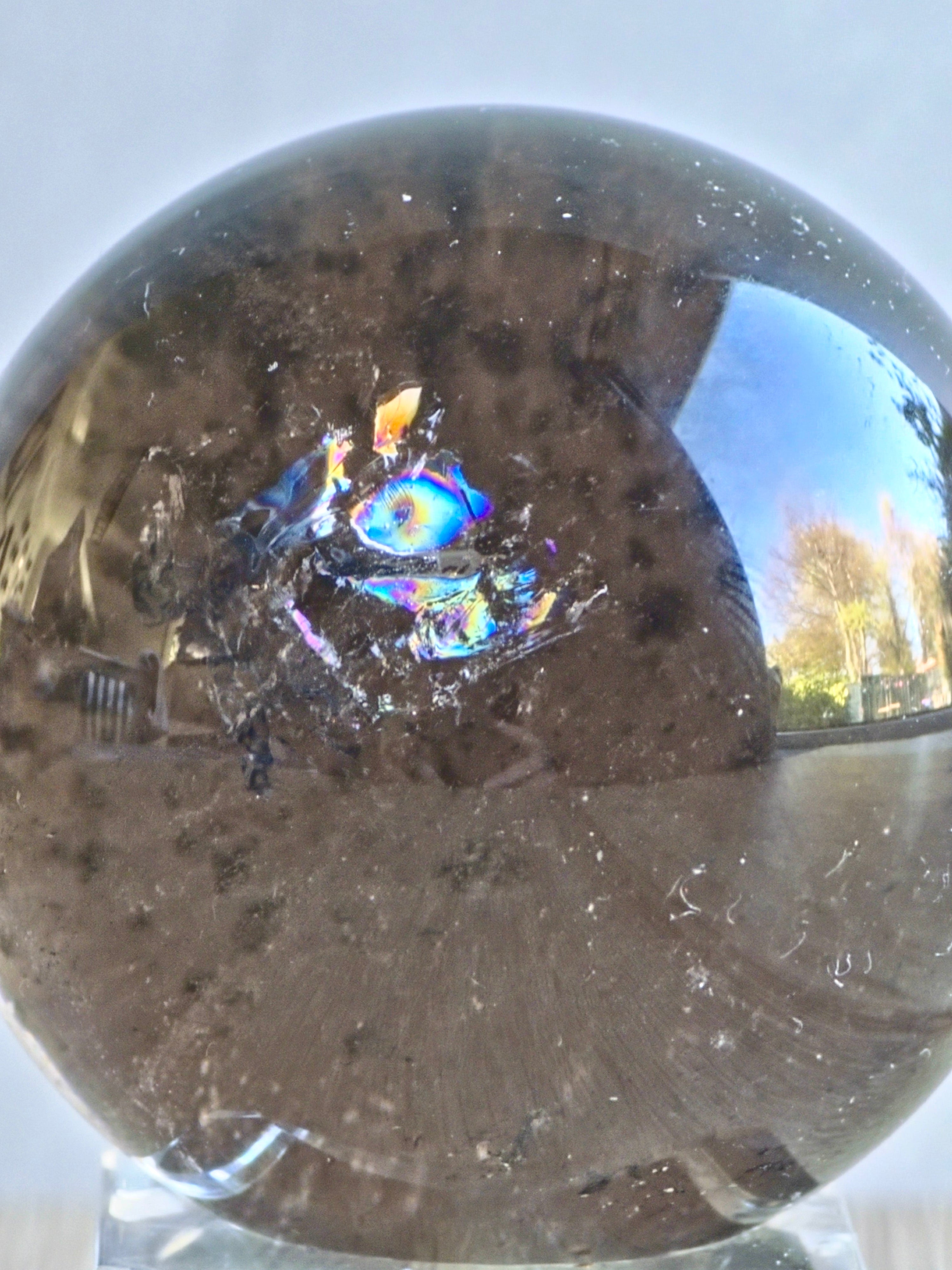 Smoky quartz sphere with green chlorite inclusions and rainbow
