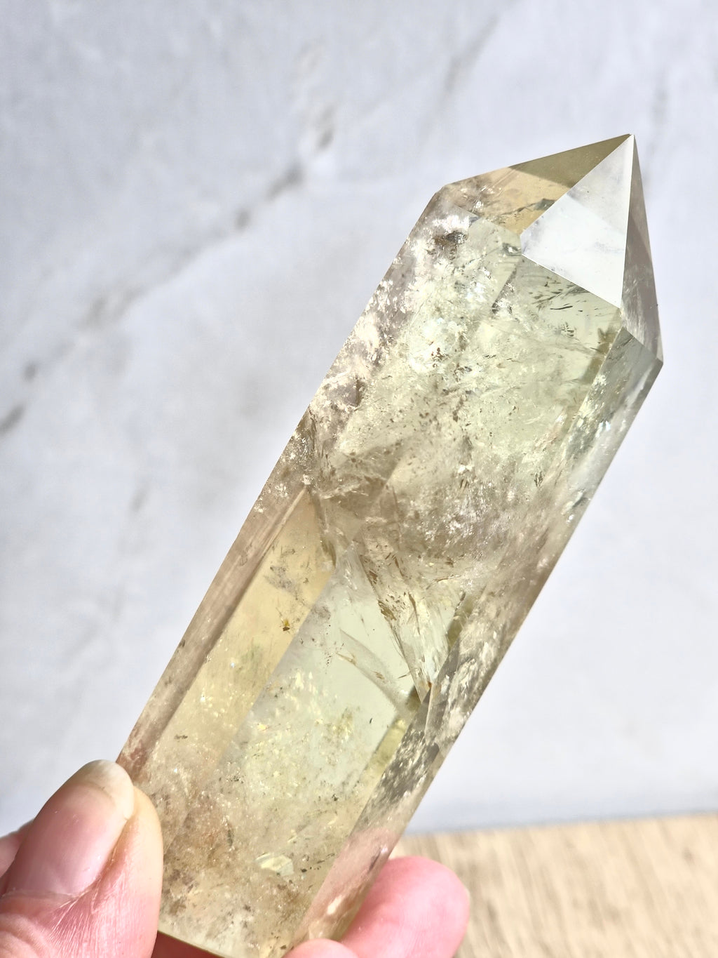 Natural citrine polished point featuring phantom formations and rainbow inclusion