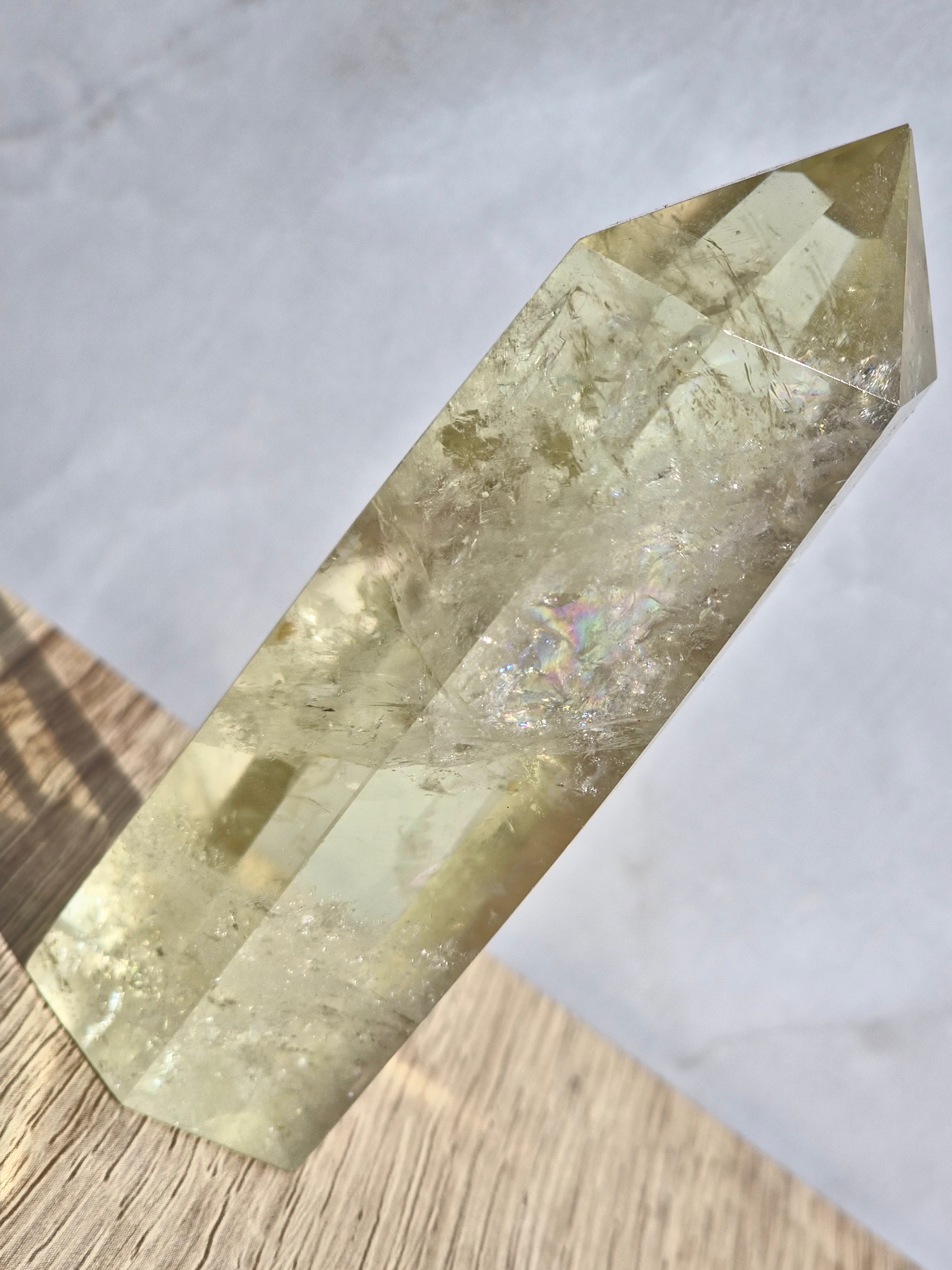 Natural citrine polished point featuring phantom formations and rainbow inclusion