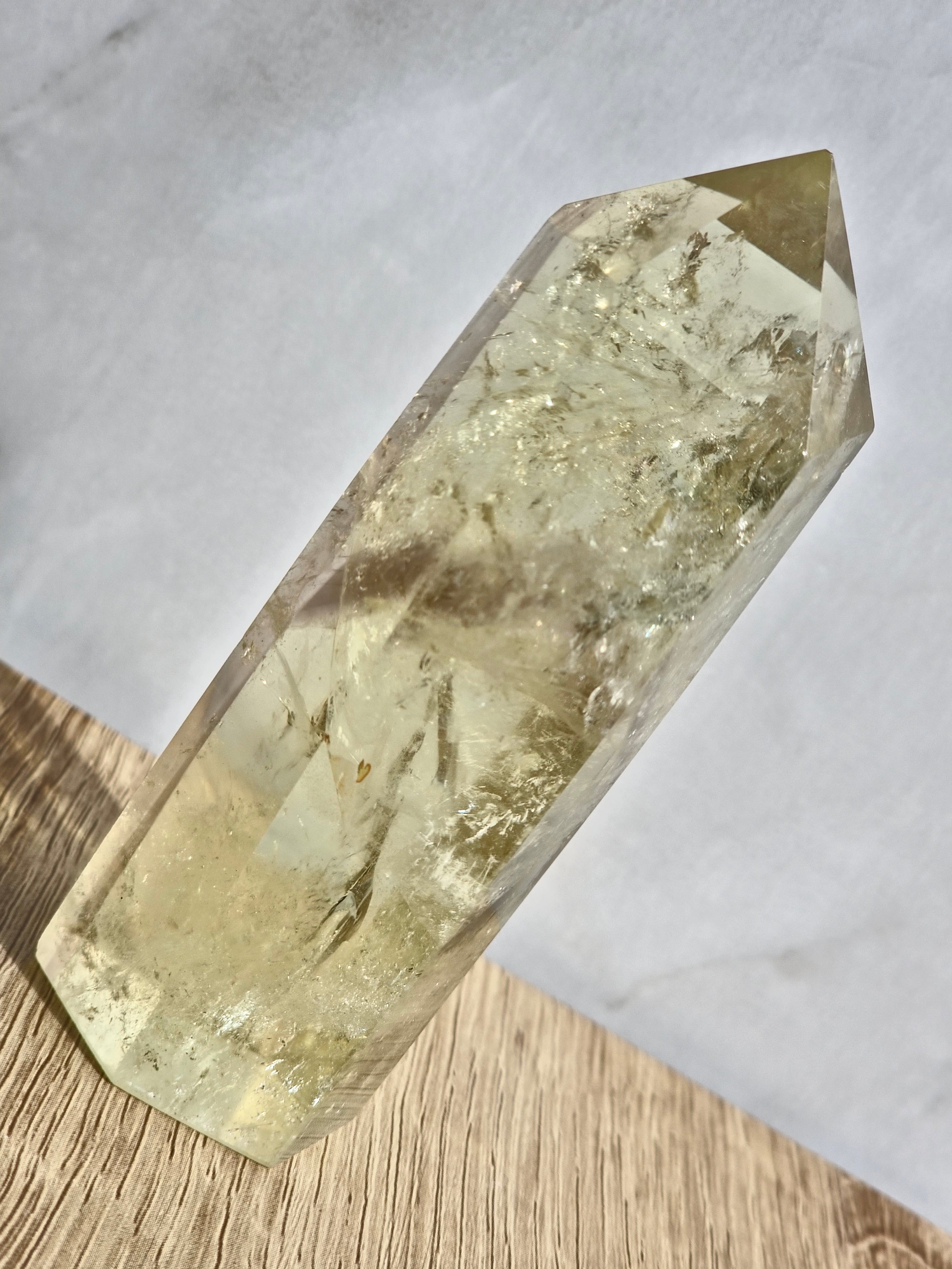 Natural citrine polished point featuring phantom formations and rainbow inclusion