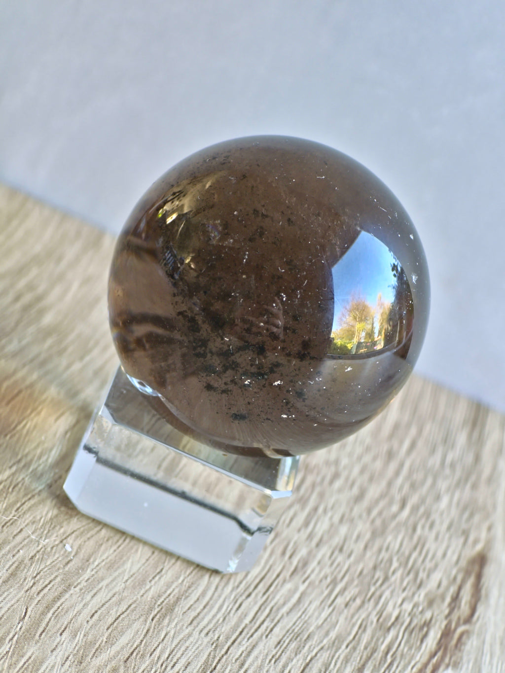 Smoky quartz sphere with green chlorite inclusions and rainbow